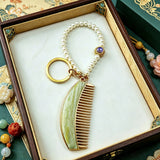 These mini comb keychains are crafted with elegant Chinese Song brocade fabric, showcasing classic traditional patterns in soft green, blush pink, and vintage cream tones. Each delicate hair comb pendant is matched with a glossy pearl lanyard and golden hardware, blending ancient oriental aesthetics with portable daily accessory design. A charming small heritage-style ornament perfect for bags, keys and gifting.