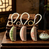  These mini comb keychains are crafted with elegant Chinese Song brocade fabric, showcasing classic traditional patterns in soft green, blush pink, and vintage cream tones. Each delicate hair comb pendant is matched with a glossy pearl lanyard and golden hardware, blending ancient oriental aesthetics with portable daily accessory design. A charming small heritage-style ornament perfect for bags, keys and gifting.