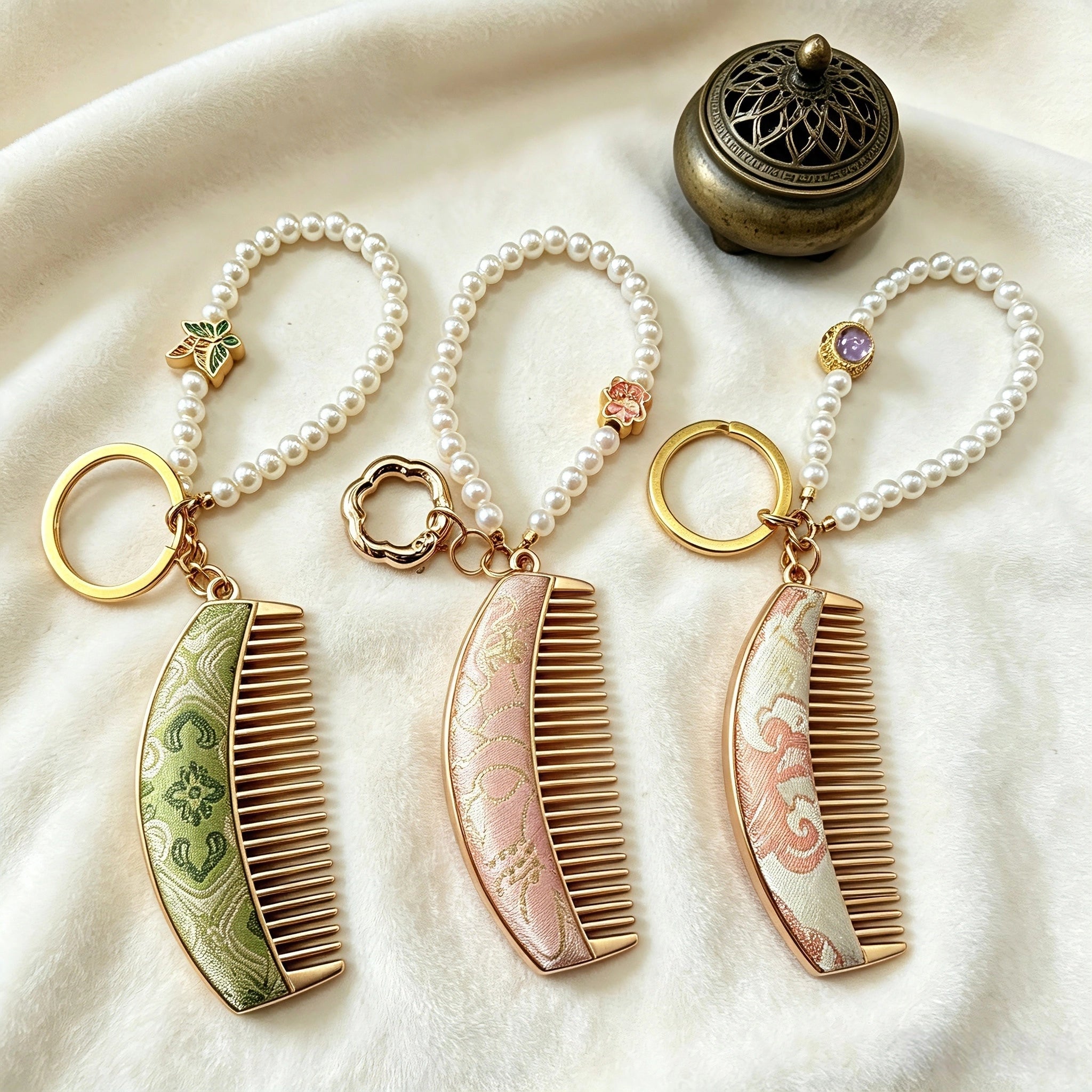  These mini comb keychains are crafted with elegant Chinese Song brocade fabric, showcasing classic traditional patterns in soft green, blush pink, and vintage cream tones. Each delicate hair comb pendant is matched with a glossy pearl lanyard and golden hardware, blending ancient oriental aesthetics with portable daily accessory design. A charming small heritage-style ornament perfect for bags, keys and gifting.