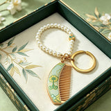  These mini comb keychains are crafted with elegant Chinese Song brocade fabric, showcasing classic traditional patterns in soft green, blush pink, and vintage cream tones. Each delicate hair comb pendant is matched with a glossy pearl lanyard and golden hardware, blending ancient oriental aesthetics with portable daily accessory design. A charming small heritage-style ornament perfect for bags, keys and gifting.
