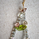 This is a grey czech beads bracelet, decorated with green leaves , bronze and purple flowers, and irregularly shape amber color spacer beads.