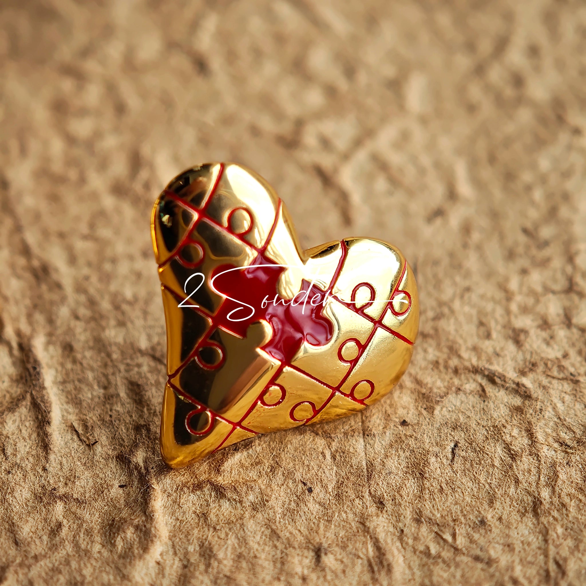 This is a pair of heart earrings with puzzle blocks pattern on the surface. The earrings feature a vibrant enamel center that mimics a beating heart flowing with love. The material of the earrings is sterling silver and enamel, and the color is vintage gold color