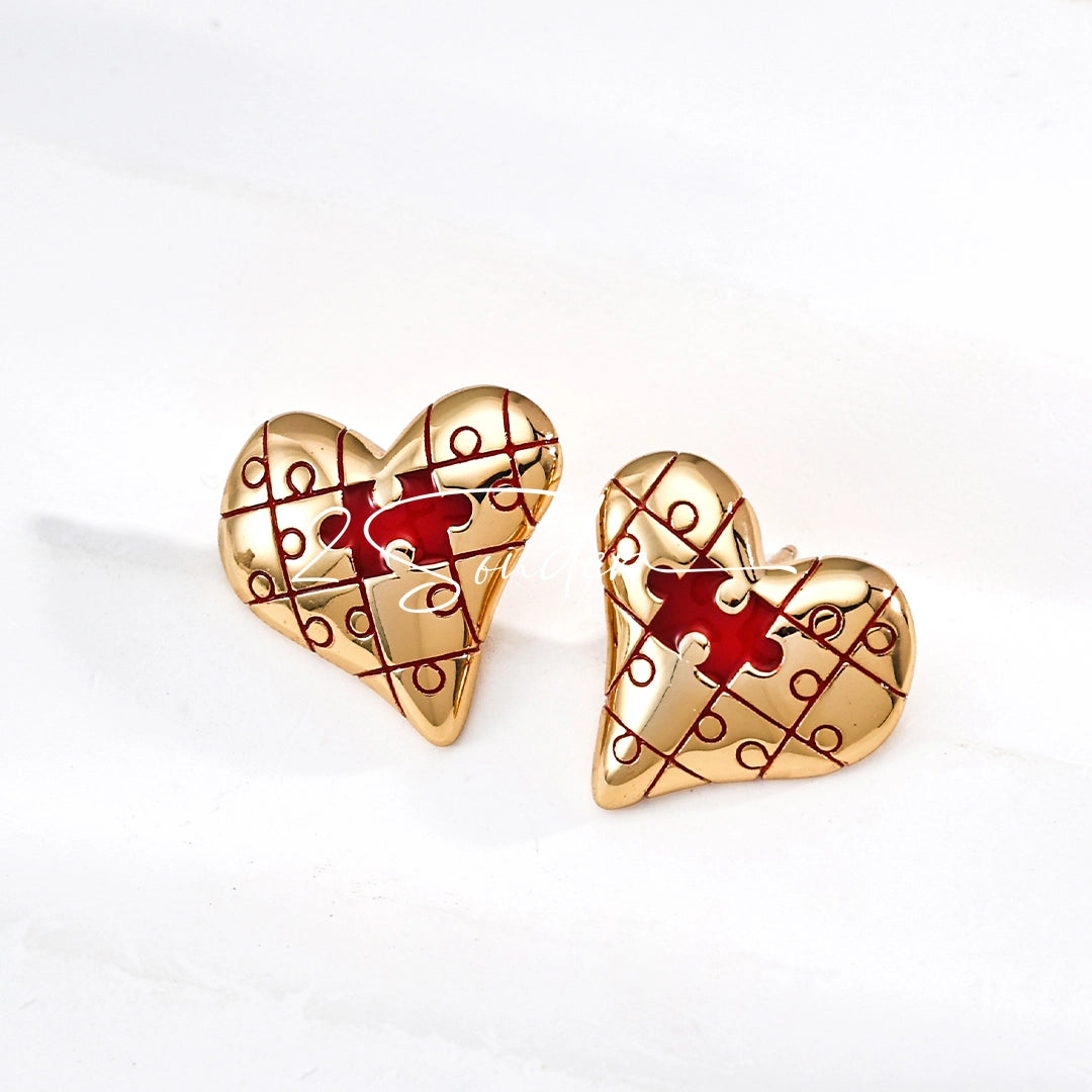 This is a pair of heart earrings with puzzle blocks pattern on the surface. The earrings feature a vibrant enamel center that mimics a beating heart flowing with love. The material of the earrings is sterling silver and enamel, and the color is vintage gold color