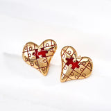 This is a pair of heart earrings with puzzle blocks pattern on the surface. The earrings feature a vibrant enamel center that mimics a beating heart flowing with love. The material of the earrings is sterling silver and enamel, and the color is vintage gold color