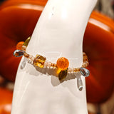 This is a bracelet made of Czech beads, orange slice spacers, leaf spacers, blue teardrop accents and elastic cord. The beads’ crystal-clear translucency catches light like dewdrops—perfect for adding a luxe touch to everyday outfits.