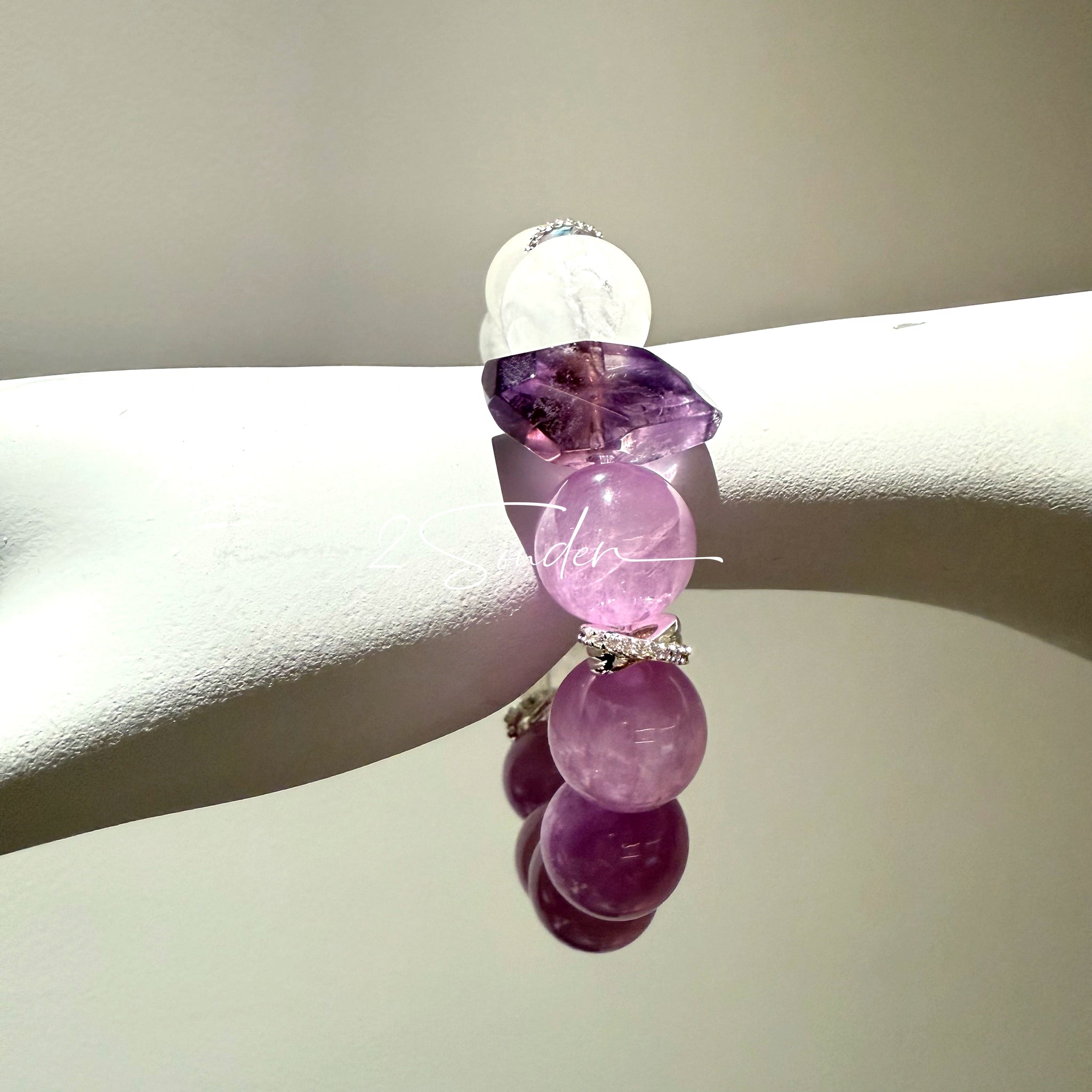 This is a multi gemstones bracelet consists of Kunzite, White Phantom Quartzs and Raw Amethysts. The beads are between 14.5 and 15.5mm. And in the bracelets, there are  hypoallergenic silver spacers and floral accents.