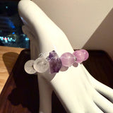This is a multi gemstones bracelet consists of Kunzite, White Phantom Quartzs and Raw Amethysts. The beads are between 14.5 and 15.5mm. And in the bracelets, there are  hypoallergenic silver spacers and floral accents.