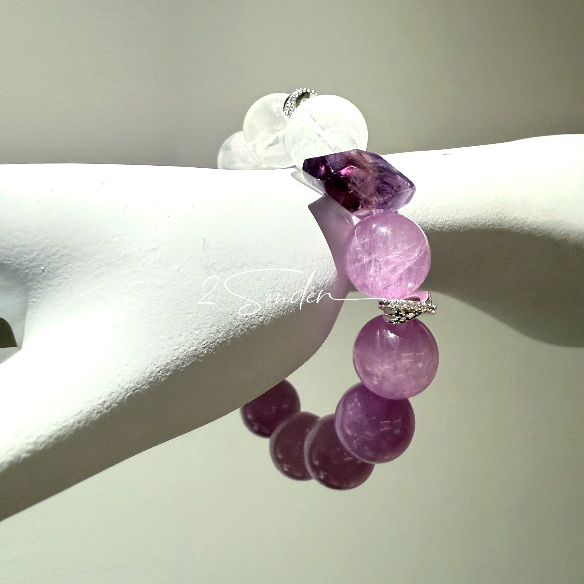 This is a multi gemstones bracelet consists of Kunzite, White Phantom Quartzs and Raw Amethysts. The beads are between 14.5 and 15.5mm. And in the bracelets, there are  hypoallergenic silver spacers and floral accents.