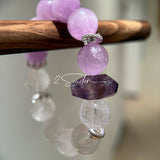 This is a multi gemstones bracelet consists of Kunzite, White Phantom Quartzs and Raw Amethysts. The beads are between 14.5 and 15.5mm. And in the bracelets, there are  hypoallergenic silver spacers and floral accents.