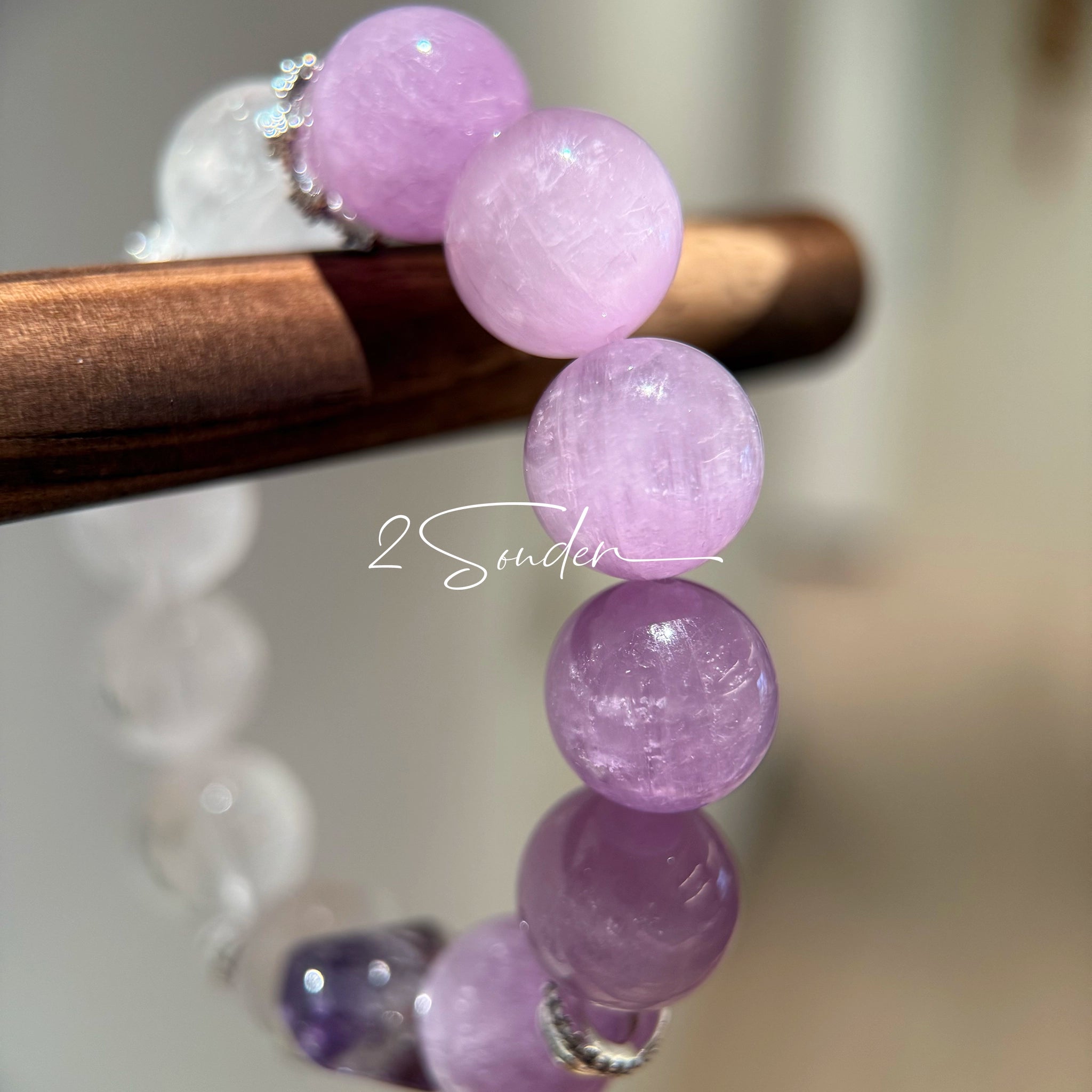 This is a multi gemstones bracelet consists of Kunzite, White Phantom Quartzs and Raw Amethysts. The beads are between 14.5 and 15.5mm. And in the bracelets, there are  hypoallergenic silver spacers and floral accents.