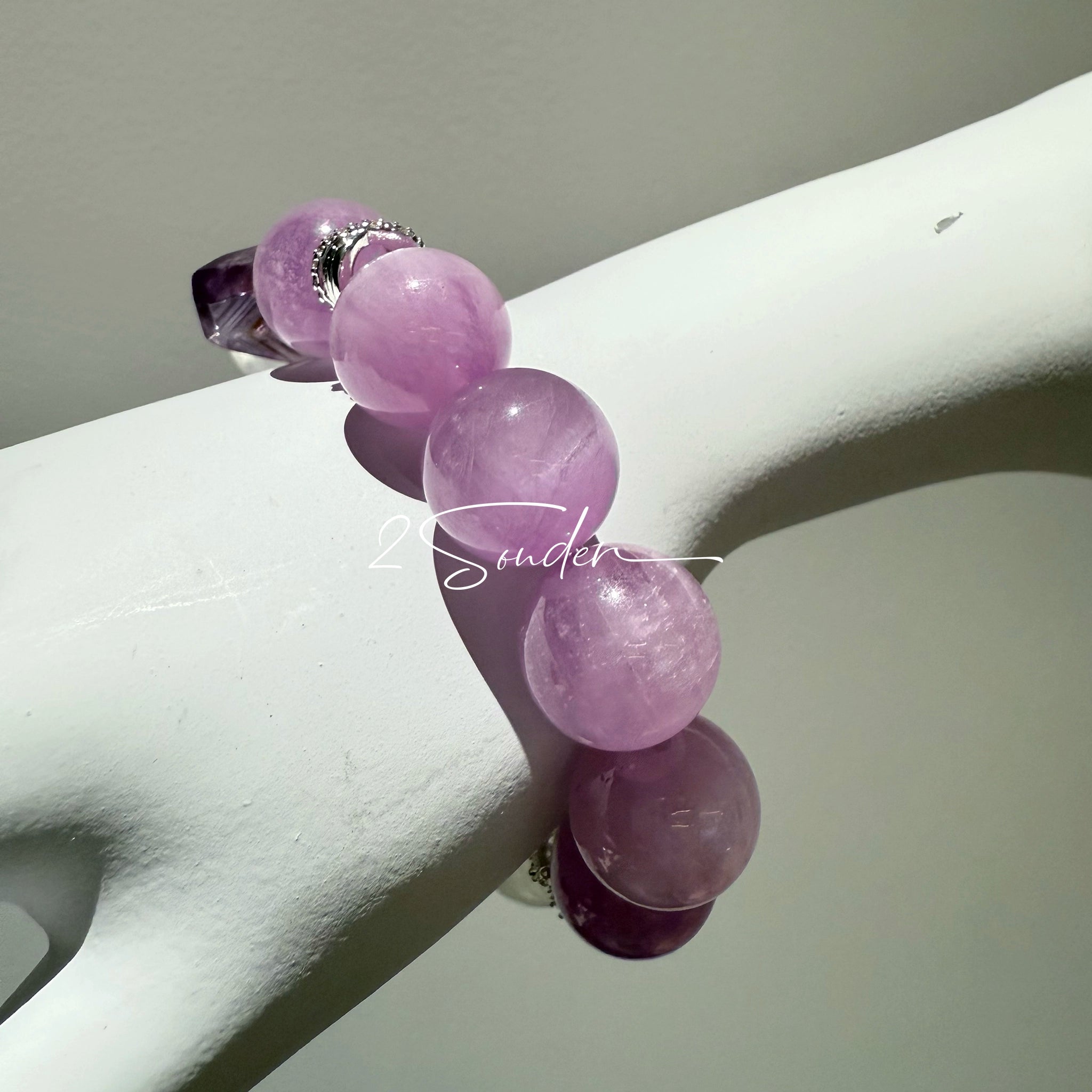 This is a multi gemstones bracelet consists of Kunzite, White Phantom Quartzs and Raw Amethysts. The beads are between 14.5 and 15.5mm. And in the bracelets, there are  hypoallergenic silver spacers and floral accents.