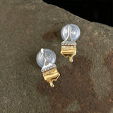 These stud earrings are designed in the shape of a paintbrush, featuring a two-tone finish with a polished silver-toned handle and a gold-toned brush head. The ferrule of the brush is encrusted with sparkling cubic zirconia stones, and the gold-toned bristles are styled to look like dripping, liquid gold paint, creating a vivid, artistic effect. Crafted with a thick 18K real gold plating, they combine a playful, creative design with elegant, eye-catching sparkle.