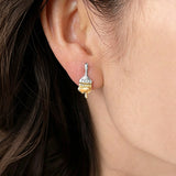 These stud earrings are designed in the shape of a paintbrush, featuring a two-tone finish with a polished silver-toned handle and a gold-toned brush head. The ferrule of the brush is encrusted with sparkling cubic zirconia stones, and the gold-toned bristles are styled to look like dripping, liquid gold paint, creating a vivid, artistic effect. Crafted with a thick 18K real gold plating, they combine a playful, creative design with elegant, eye-catching sparkle.