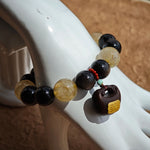 This strand balances midnight glass and daylight needles, then finishes with fragrant wood and scarlet jade.