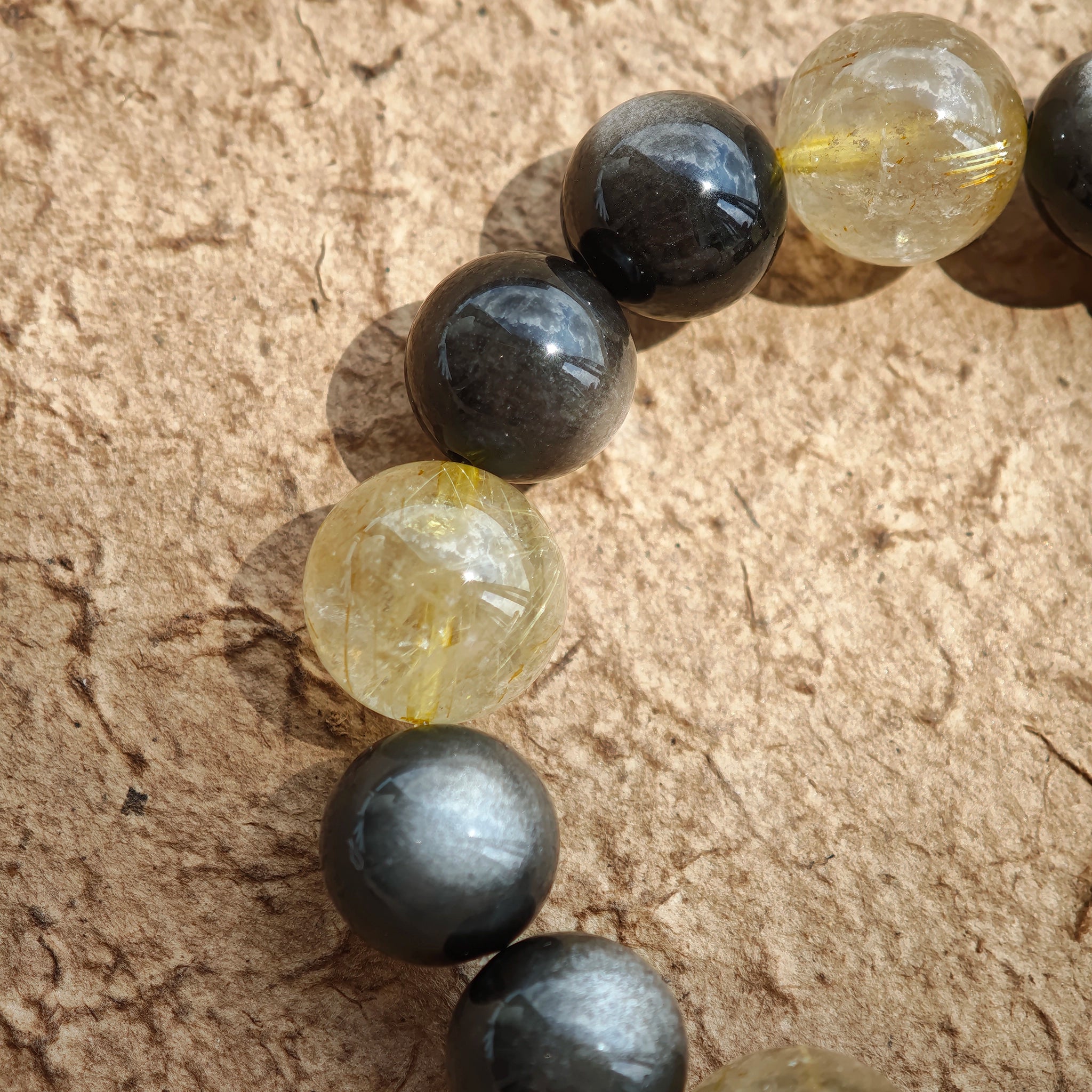 This 12–13.8 mm bracelet marries lunar silver obsidian with solar golden rutile, finished with sacred agarwood and imperial Nanhong.