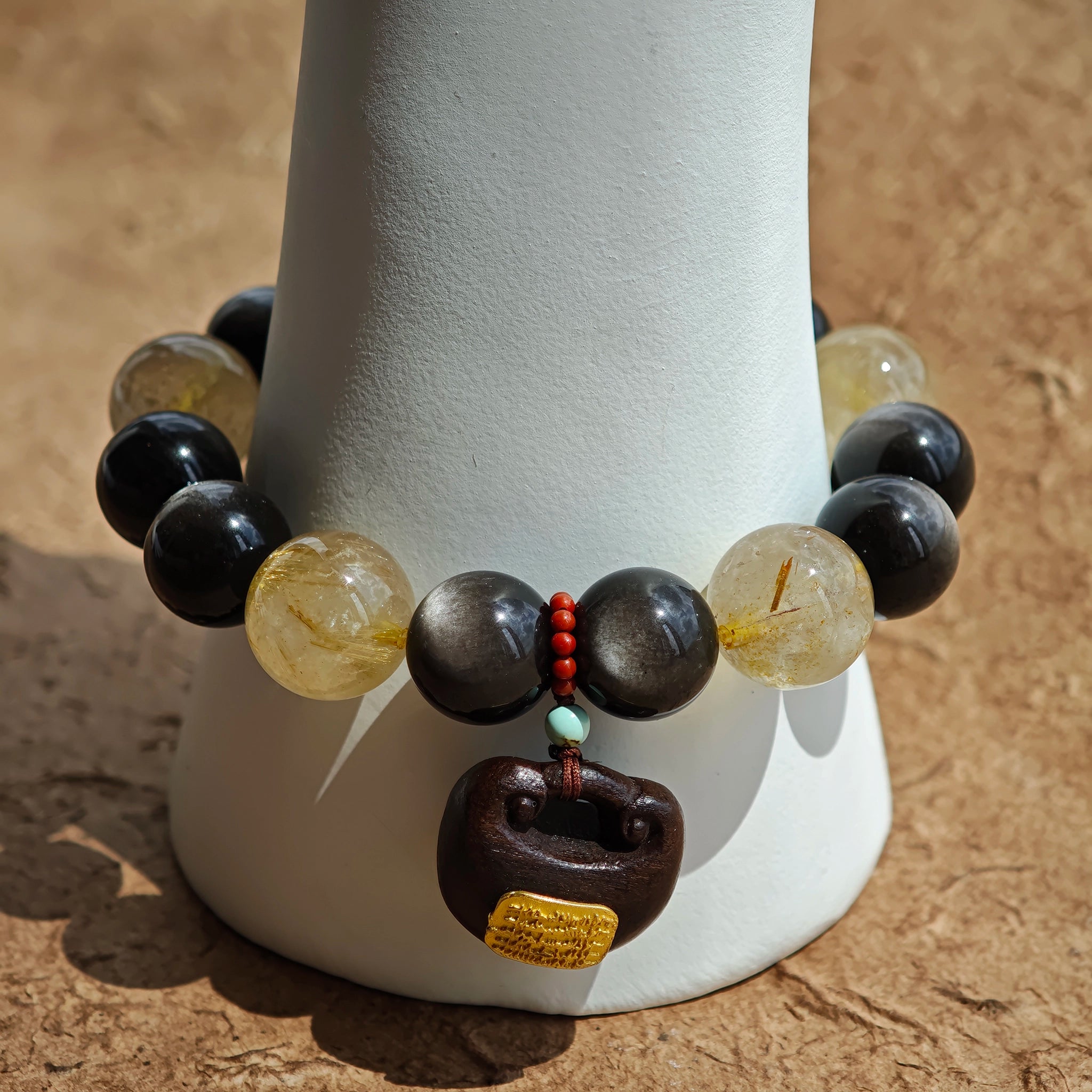 A regal strand of silver-obsidian shields and golden rutile sunbursts, anchored by fragrant agarwood and crimson Nanhong agate.