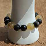 Gleaming silver obsidian spheres meet radiant golden rutile beads, then sink into the earthy warmth of agarwood and fiery Nanhong agate.