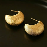These minimalist high-end stud earrings feature a plump crescent C-shaped design with delicate frosted texture on the whole surface. They are available in two classic colors: elegant gold and versatile silver. With smooth curved lines, the earrings bring understated luxury and fashionable daily wear sense.