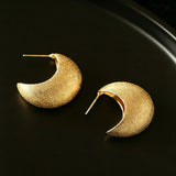 These minimalist high-end stud earrings feature a plump crescent C-shaped design with delicate frosted texture on the whole surface. They are available in two classic colors: elegant gold and versatile silver. With smooth curved lines, the earrings bring understated luxury and fashionable daily wear sense.