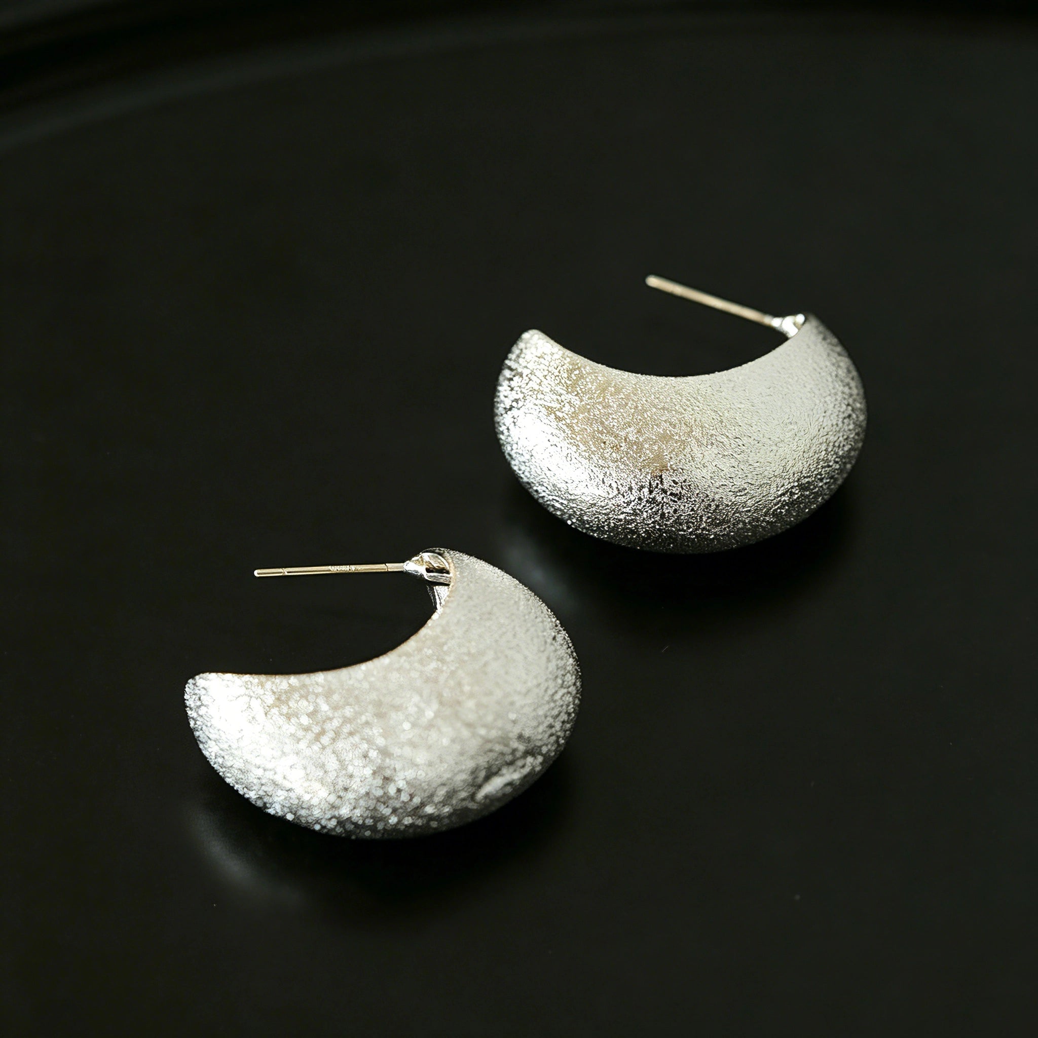 These minimalist high-end stud earrings feature a plump crescent C-shaped design with delicate frosted texture on the whole surface. They are available in two classic colors: elegant gold and versatile silver. With smooth curved lines, the earrings bring understated luxury and fashionable daily wear sense.