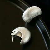 These minimalist high-end stud earrings feature a plump crescent C-shaped design with delicate frosted texture on the whole surface. They are available in two classic colors: elegant gold and versatile silver. With smooth curved lines, the earrings bring understated luxury and fashionable daily wear sense.