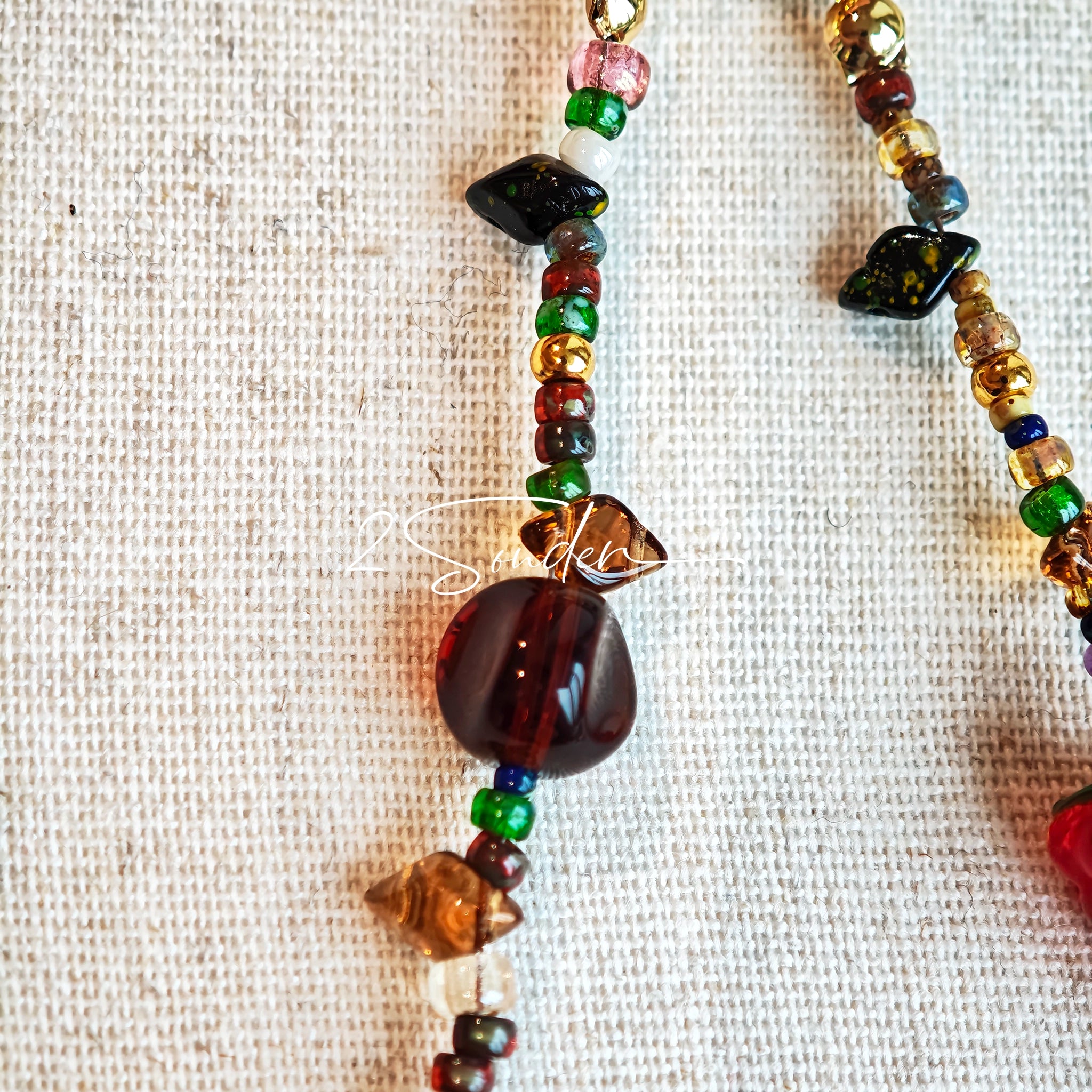 This handmade Czech glass bead bag charm is also perfect as a phone strap, keychain accessory, or a car decor. Featuring translucent beads, fruity spacers (pear, lemon, strawberry!), whimsical floral leaves and durable gold-tone hardware, it’s like wearing a garden on your keys.