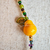 This handmade Czech glass bead bag charm is also perfect as a phone strap, keychain accessory, or a car decor. Featuring translucent beads, fruity spacers (pear, lemon, strawberry!), whimsical floral leaves and durable gold-tone hardware, it’s like wearing a garden on your keys.