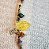 This handmade Czech glass bead bag charm is also perfect as a phone strap, keychain accessory, or a car decor. Featuring translucent beads, fruity spacers (pear, lemon, strawberry!), whimsical floral leaves and durable gold-tone hardware, it’s like wearing a garden on your keys.