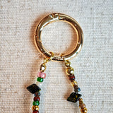 This handmade Czech glass bead bag charm is also perfect as a phone strap, keychain accessory, or a car decor. Featuring translucent beads, fruity spacers (pear, lemon, strawberry!), whimsical floral leaves and durable gold-tone hardware, it’s like wearing a garden on your keys.