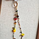 This handmade Czech glass bead bag charm is also perfect as a phone strap, keychain accessory, or a car decor. Featuring translucent beads, fruity spacers (pear, lemon, strawberry!), whimsical floral leaves and durable gold-tone hardware, it’s like wearing a garden on your keys.