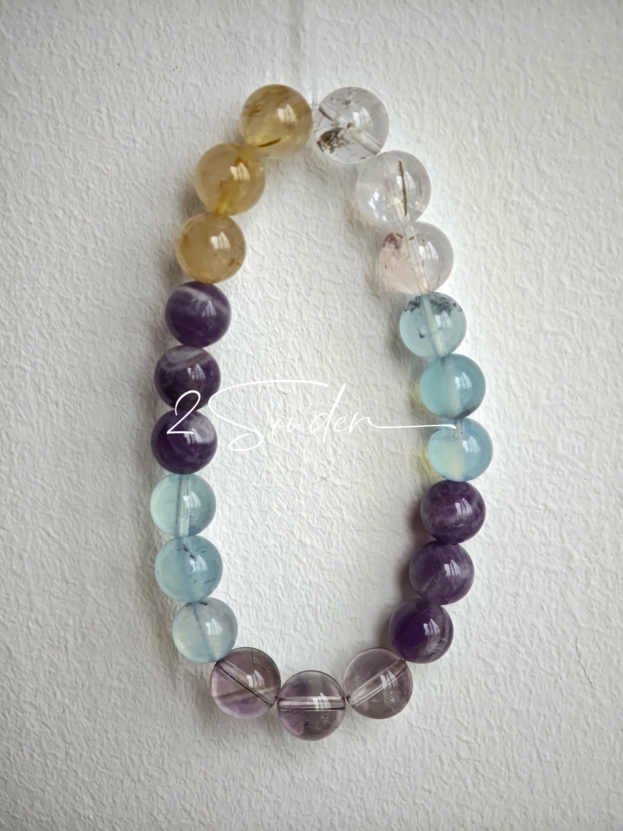 This is a gemstone bracelet consists of different gemstones. They are blue aquamarines, purple amethysts, yellow citrines and transparent clear quartz. It's with 16cm circumference.