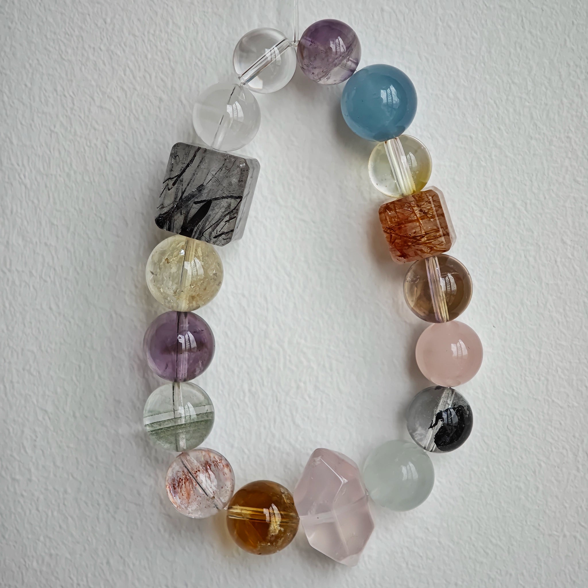 This multi gemstone bracelet features aquamarine, amethyst, strawberry quartz, rose quartz, green phantom quartz, and black rutilated quartz.