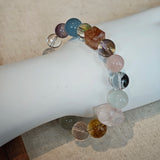 This multi gemstone bracelet features aquamarine, amethyst, strawberry quartz, rose quartz, green phantom quartz, and black rutilated quartz.