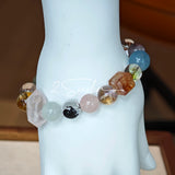 This stunning multi-gem crystal bracelet is a vibrant rainbow of natural stones, featuring smooth round beads in hues of clear, amethyst, sky blue, soft pink, golden, and smoky brown, interspersed with striking square and geometric-cut accents.
Each bead showcases unique inclusions: delicate black rutile in the gray square, fiery red hair-like strands in the brown square, and subtle mineral veining throughout, creating a one-of-a-kind, textured masterpiece.
The eclectic mix of gemstones—from amethyst and ro