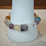 This multi gemstone bracelet features aquamarine, amethyst, strawberry quartz, rose quartz, green phantom quartz, and black rutilated quartz.