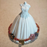 Vibrant pink Czech glass beads are highlighted by blue, purple, and black flower charms and green leaf accents, creating a stunningly attractive design.