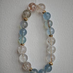 Aquamarine serenity and rutile brilliance dance between delicate gold beads.