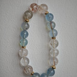 Aquamarine serenity and rutile brilliance dance between delicate gold beads.