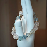 Cool waves of aqua roll beside golden rutile threads, tied with polished gold.