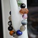 Wrapped in smoky indigo, the bracelet gathers Black Gold Super Seven, Herkimer diamonds, clear quartz, sandalwood, amethyst, silver obsidian, white phantom, and kyanite.