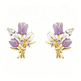 These stud earrings feature an elegant bouquet design, crafted with a thick 18K real gold plating. The arrangement showcases delicate purple and white enamel tulip flowers, accented with sparkling marquise and round-cut cubic zirconia stones, all set in a polished gold-tone metal structure tied with a decorative knot at the base. The overall style is romantic and refined, perfect for adding a touch of floral charm to any look.