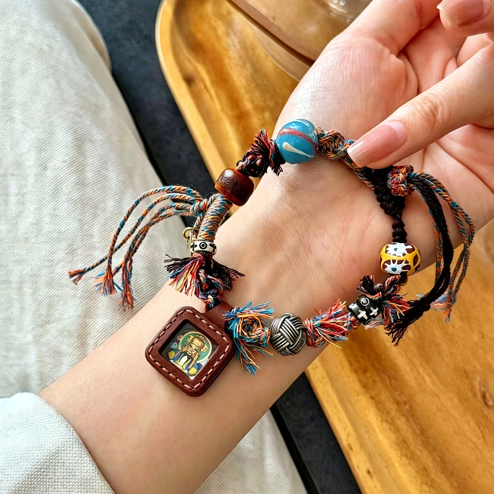 This vintage hand-woven bracelet features vibrant mixed-color tassels and diverse decorative beads. It comes with a small leather thangka pendant, blending ethnic charm with playful dopamine styling. Each braided detail is handcrafted for a unique, bohemian look.