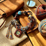 This vintage hand-woven bracelet features vibrant mixed-color tassels and diverse decorative beads. It comes with a small leather thangka pendant, blending ethnic charm with playful dopamine styling. Each braided detail is handcrafted for a unique, bohemian look.
