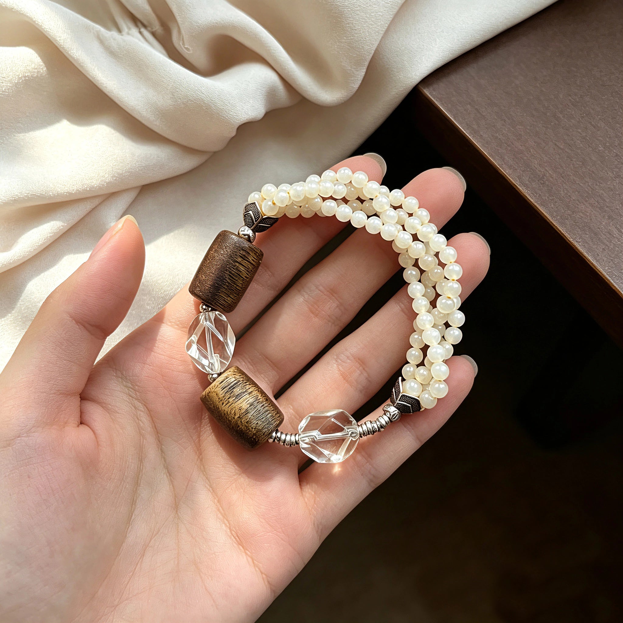 This handcrafted vintage bracelet blends creamy pale beads, textured wooden cylinders and faceted clear quartz for an earthy, bohemian look. Detailed antique silver accents add subtle depth, making it a unique layered accessory full of natural charm.