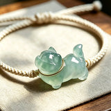 This vintage hand-woven bracelet features a lovely translucent jade-green kitten charm, paired with soft off-white braided cord. The fresh natural bamboo backdrop highlights its gentle, playful dopamine style, perfect as a delicate daily accessory. It has an adjustable knotted design for a comfortable fit on different wrist sizes.