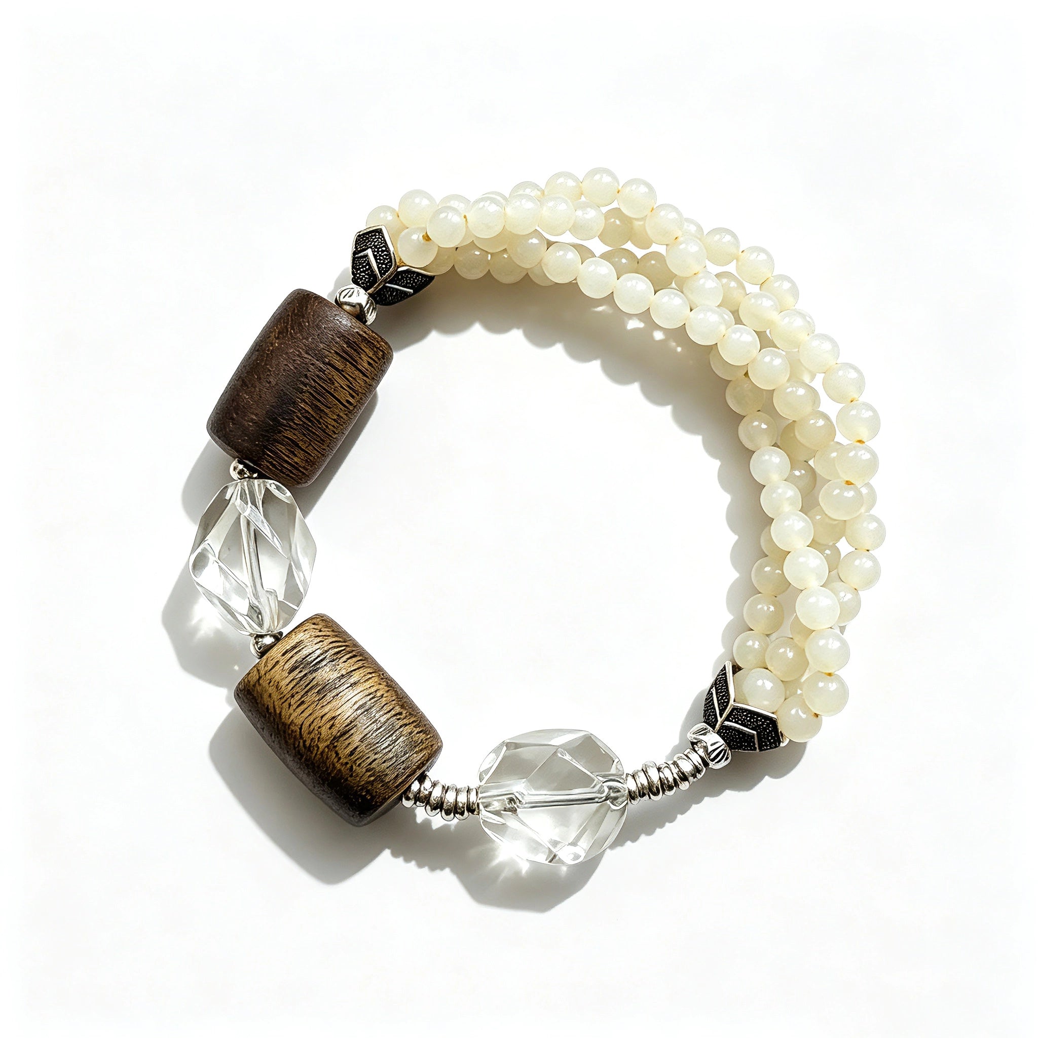 This handcrafted vintage bracelet blends creamy pale beads, textured wooden cylinders and faceted clear quartz for an earthy, bohemian look. Detailed antique silver accents add subtle depth, making it a unique layered accessory full of natural charm.