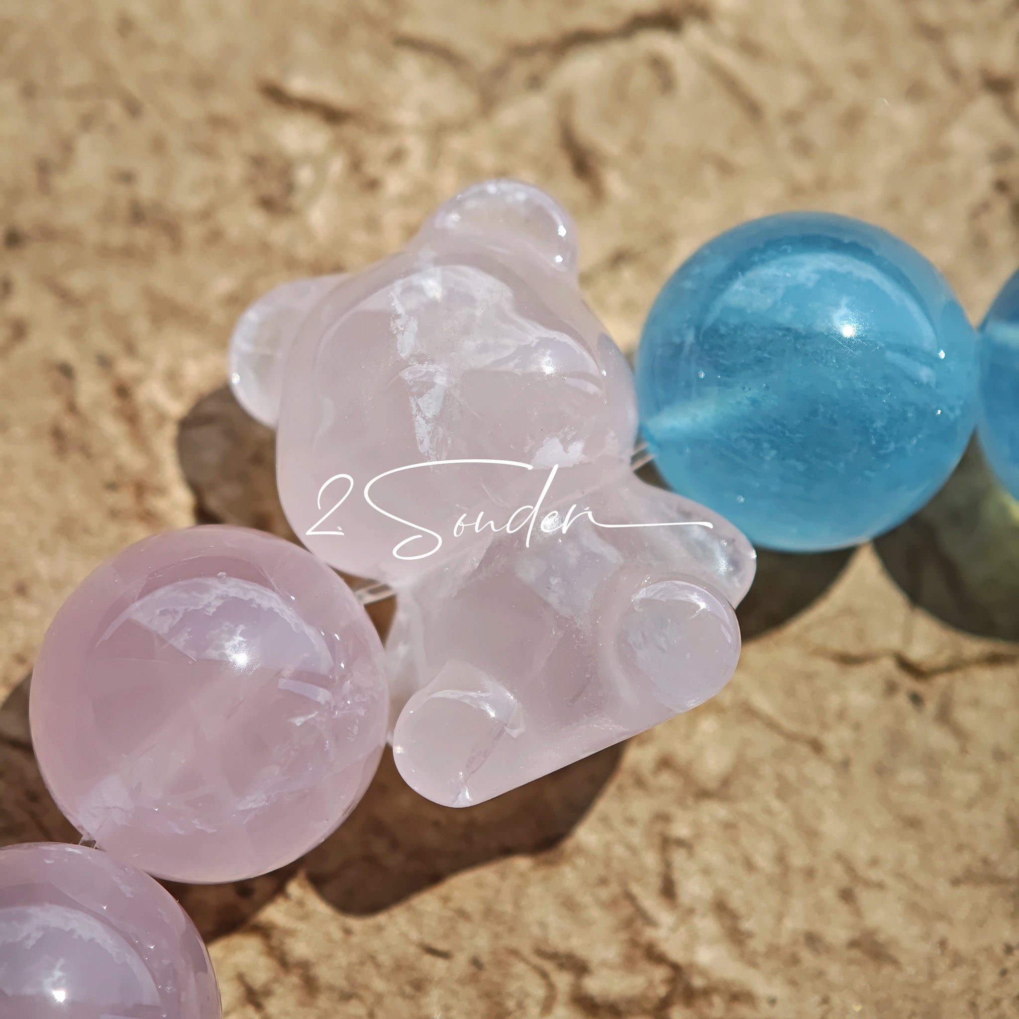 This bracelet consists of rose quartz and aquamarine. The bracelet features a bead pendant and a rhombic spacer, both of which are made of rose quartz. The bracelet is a combination of pink and blue colors.