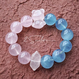 This bracelet consists of rose quartz and aquamarine. The bracelet features a bead pendant and a rhombic spacer, both of which are made of rose quartz. The bracelet is a combination of pink and blue colors.