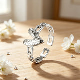 This is an adjustable open ring crafted from S925 sterling silver. It features a modern chain-link band paired with a textured heart-shaped centerpiece, boasting a "crushed ice" finish that delivers a sparkling, dimensional look. The polished silver tone lends a sleek, contemporary vibe to this versatile piece.