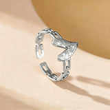 This is an adjustable open ring crafted from S925 sterling silver. It features a modern chain-link band paired with a textured heart-shaped centerpiece, boasting a "crushed ice" finish that delivers a sparkling, dimensional look. The polished silver tone lends a sleek, contemporary vibe to this versatile piece.